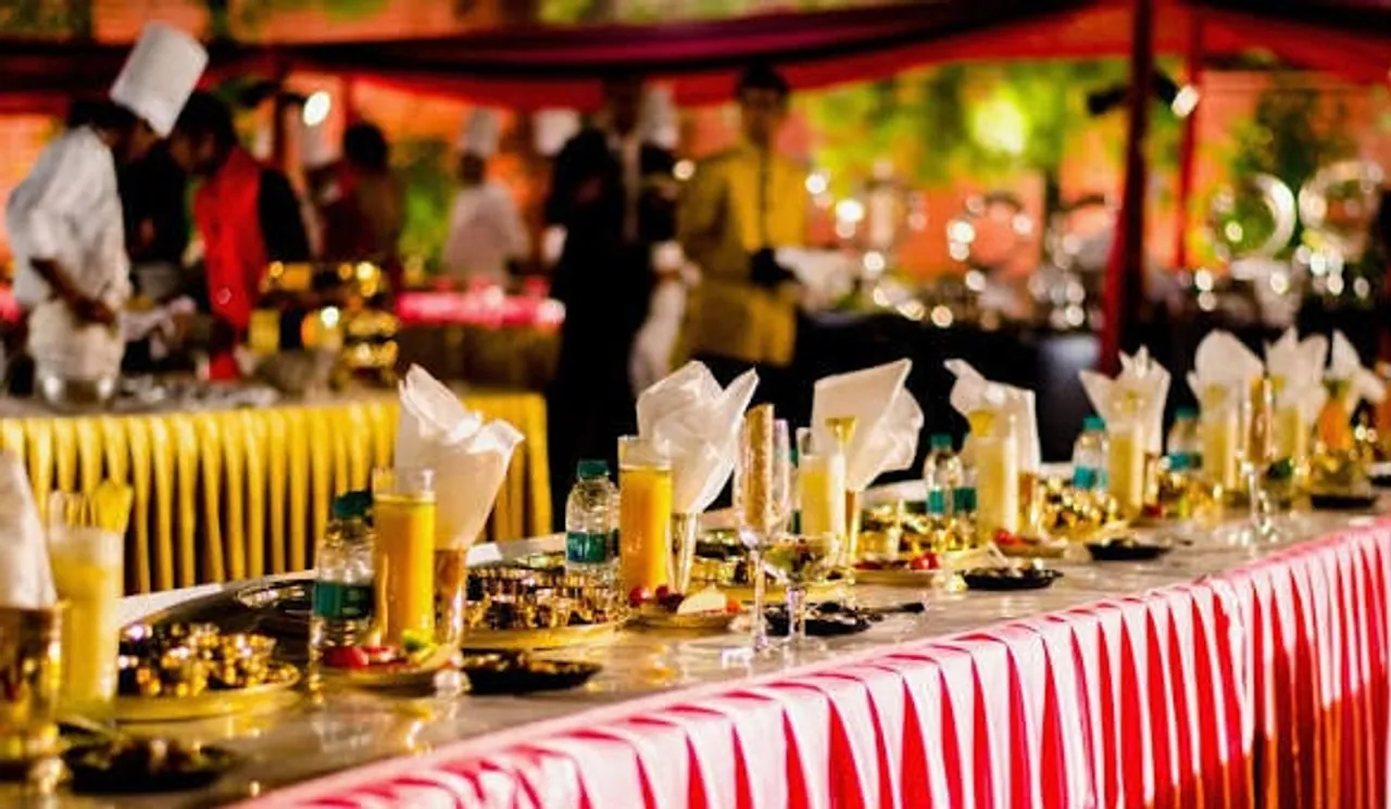 Evening wedding buffet with welcome drinks, folded napkins and chefs serving in the background